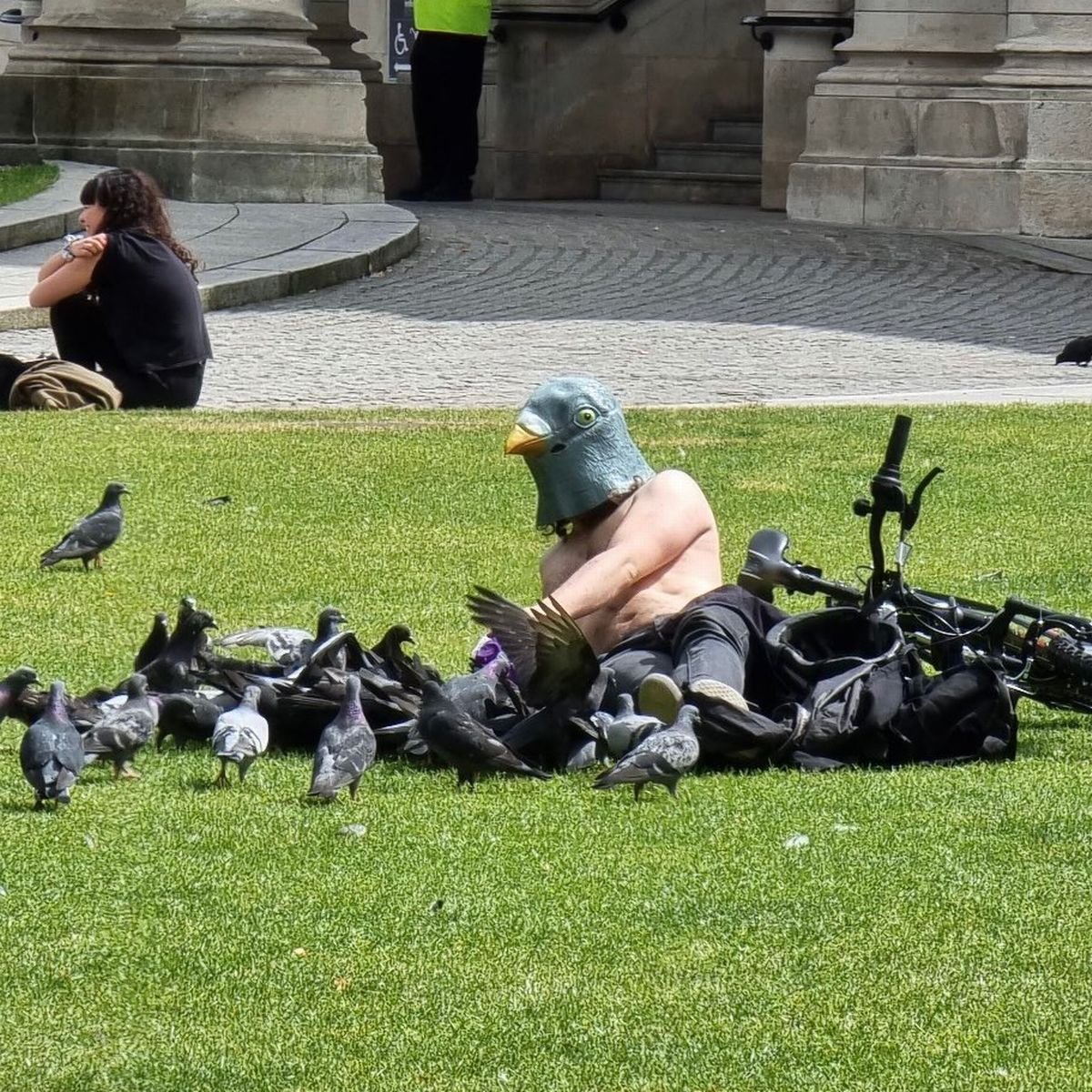 The meme features a person wearing a ridiculous-looking pigeon mask, sitting on the ground surrounded by pigeons. The text above the image reads, "I'm not a pigeon, I'm just a guy who likes pigeons." The image is humorous because it's a play on the common stereotype that pigeon enthusiasts are actually pigeon people. The person in the mask is poking fun at this stereotype, implying that they're not actually a pigeon, but rather someone who just enjoys pigeon-related things.